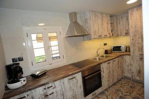 una cucina con armadi in legno, lavandino e finestra di CRECIAN WATER FRONT a Egira
