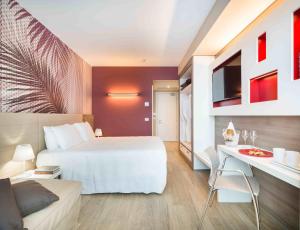 a bedroom with a bed and a table and a couch at Enjoy Garda Hotel in Peschiera del Garda