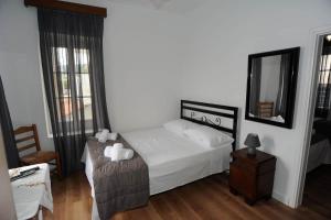 a bedroom with a white bed and a mirror at CRECIAN WATER FRONT in Egira