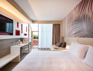 a hotel room with a large bed and a living room at Enjoy Garda Hotel in Peschiera del Garda