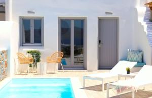 un patio con piscina, sedie e una casa di The Nine Graces - Agia Anna - Option With private pool or hot tub ad Agia Anna Naxos