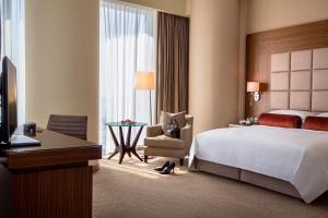 Un pat sau paturi într-o cameră la City Centre Rotana Doha