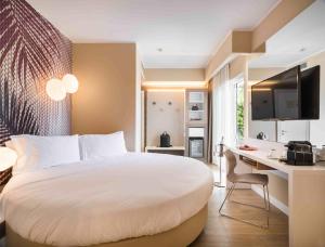 a bedroom with a bed and a desk with a computer at Enjoy Garda Hotel in Peschiera del Garda