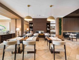 a restaurant with tables and chairs in a room at Enjoy Garda Hotel in Peschiera del Garda