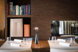 a table with white napkins and a lamp on it at Enjoy Garda Hotel in Peschiera del Garda