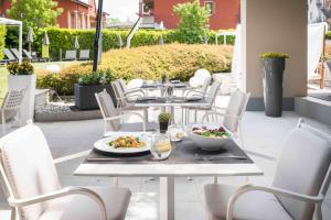 a table and chairs with plates of food on a patio at Enjoy Garda Hotel in Peschiera del Garda