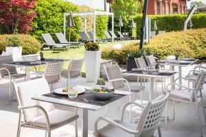 a row of tables and chairs on a patio at Enjoy Garda Hotel in Peschiera del Garda