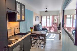 une cuisine avec un comptoir et une table avec des chaises dans l'établissement Gîte du rempart avec Balnéo, Garage, 2 SDB 2WC vue sur les monuments, au Puy-en-Velay