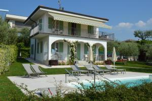 una casa con sillas y una piscina frente a ella en Casa Balter, en Bardolino