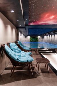 a room with a swimming pool and chairs and a table at Pinea Hotel Resort & Spa in Golem