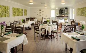 un comedor con mesas y sillas blancas en Hillgrove Guesthouse, en Dingle
