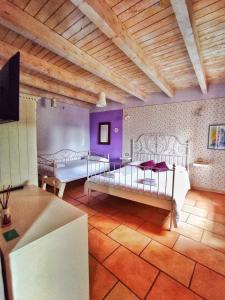 two beds in a room with purple walls and wooden ceilings at Rocca dell'Innominato in Lecco