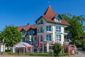 un grand bâtiment blanc avec un toit rouge dans l'établissement FEWO Ava - im Sommer ist ein Strandkorb inclusive, à Zempin
