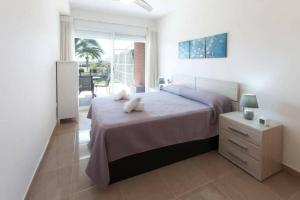 a bedroom with a bed and a table with a night stand at Paradise - Oliva Nova playa MET&GOLF in Oliva +26 photos