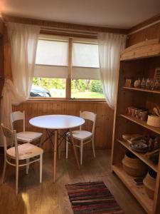 mesa y sillas en una habitación con ventana en Dom Pod Długim Wiosłem, en Wiartel
