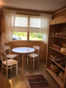 a table and chairs in a room with a window at Dom Pod Długim Wiosłem in Wiartel