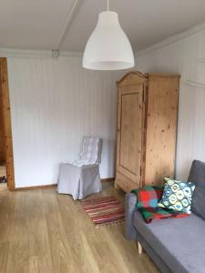 a living room with a couch and a chair at Dom Pod Długim Wiosłem in Wiartel