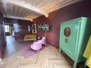 um quarto com uma cadeira rosa e um armário verde em Boutique Hotel Zeeuws-Meisje em Zierikzee