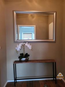 a mirror on a wall with a vase of flowers on a table at Top Modernes Rhein Apartment Vallendar in Vallendar