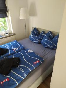 a bed with blue sheets and pillows on it at Gemütliche Haushälfte mit Garten und Terrasse in Flensburg