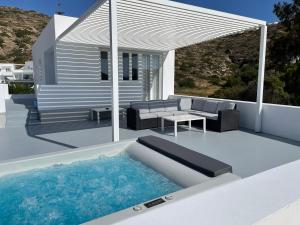 a pool on a patio with a couch and a table at Relux Ios Hotel in Ios Chora