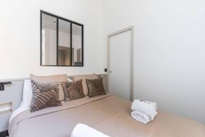 a bedroom with a large bed with a mirror on the wall at HSH Volney-Opéra Appartement Design 4P-1BR in Paris