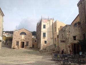 un grupo de edificios de piedra con mesas y sillas en Casa del mare Borgio Verezzi, en Borgio Verezzi