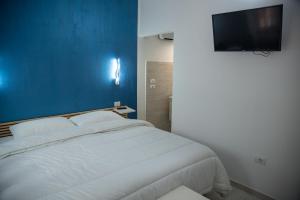 a bedroom with a white bed and a flat screen tv at VISTAMARE VILLAGE in Silvi Marina