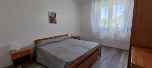 Schlafzimmer mit einem Bett und einem Fenster in der Unterkunft Appartamenti Lino in Caorle