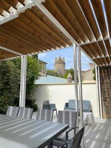 un patio con una mesa y sillas y un castillo en Vue sur Cité - SPA en Carcassonne