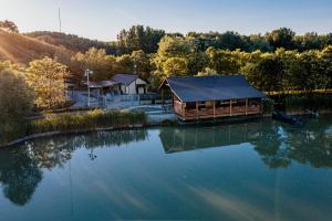 una cabaña en un lago con el reflejo en el agua en Tíztó Vendégház, en Baja