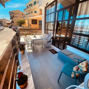 a patio with a table and chairs on a balcony at Corfu port apartment in Mantoúkion