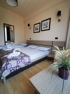- une chambre avec 2 lits et une table dans l'établissement Vila Sangria, à Mamaia Nord – Năvodari