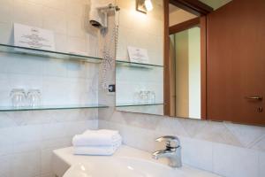 W łazience znajduje się umywalka, lustro i ręczniki. w obiekcie Agriturismo Contessi w mieście San Daniele del Friuli