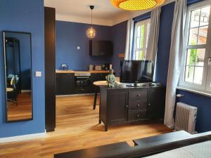 d'un salon avec des murs bleus et une table avec une télévision. dans l'établissement Apartment 24, à Cobourg