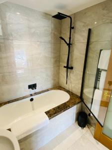 a bathroom with a bath tub and a toilet at The Star Inn 1744 in Thrussington