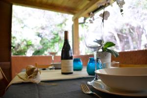 einen Tisch mit einer Flasche Wein und einer Schüssel in der Unterkunft Beach House Calaverde Village in Santa Margherita di Pula