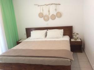 a bedroom with a bed with white sheets and green curtains at Villa Popi in Methana