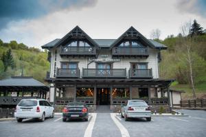 un gran edificio con coches estacionados en un estacionamiento en Chalet Carpat Dream en Synevyr