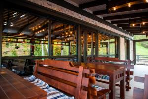 a restaurant with benches and a table and windows at Chalet Carpat Dream in Synevyr
