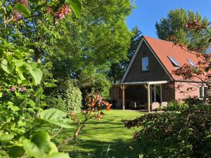 a black house with a red roof in a yard at Vakantiehuis Sonnewende in Veere