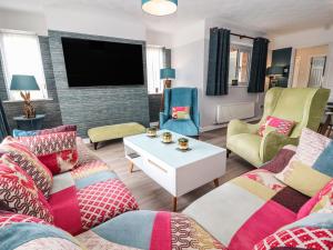 a living room with two couches and a tv at Rose Hill in Holywell