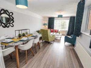 a dining room and living room with a table and chairs at Rose Hill in Holywell