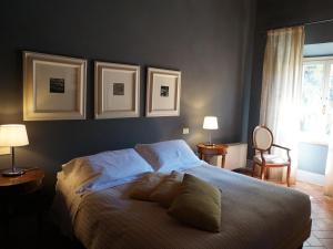 um quarto com uma cama com três fotografias na parede em Borgo Colleoli Resort em Colleoli