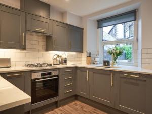 a kitchen with gray cabinets and a window at Lower Sheriff's Place in Windermere