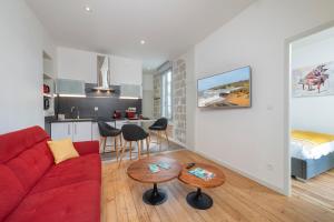 uma sala de estar com um sofá vermelho e uma cozinha em Hyper Centre 14 rue Valdemaine em Angers
