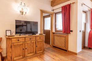 een woonkamer met een televisie op een houten dressoir bij Casa Cristallo in Cortina dʼAmpezzo