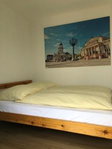 Bett in einem Zimmer mit einem Bild an der Wand in der Unterkunft CLUB Lodges Berlin Mitte in Berlin
