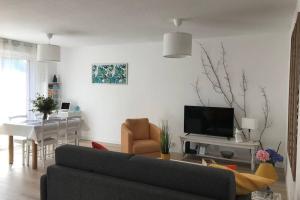 ein Wohnzimmer mit einem Sofa und einem Esszimmer in der Unterkunft LE LOGIS DES JALLES in Saint-Médard-en-Jalles