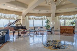 ein Wohnzimmer mit Klavier, Tisch und Stühlen in der Unterkunft Summit Hotel in Gaeta